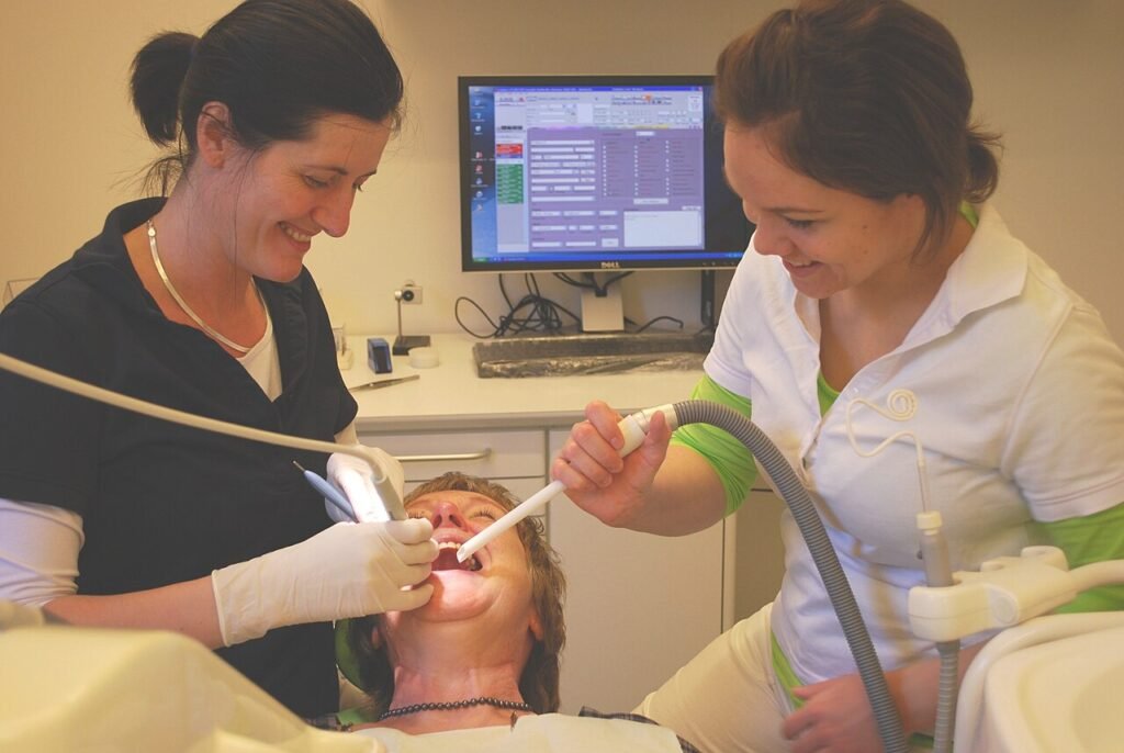 Dentista revisando la boca de una paciente durante una consulta odontológica