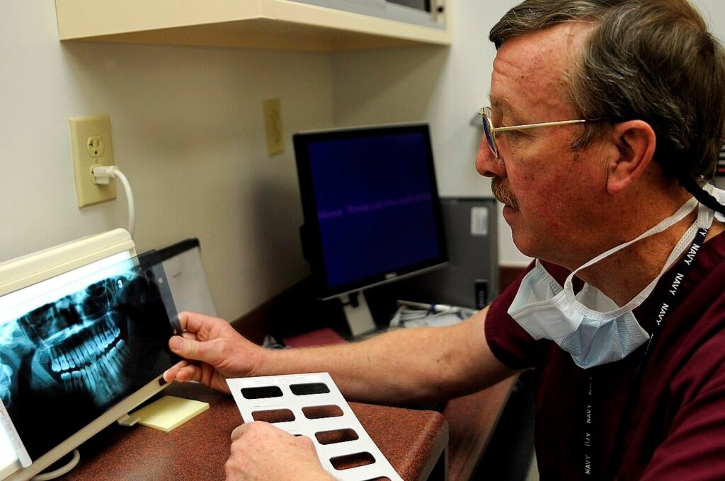 Dentista revisando radiografías antes de explicar un plan de tratamiento dental